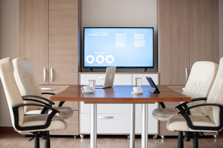 Empty business meeting conference room with graphs and diagrams on TV
