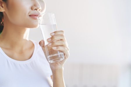 unrecognizable-woman-carrying-glass-water-mouth